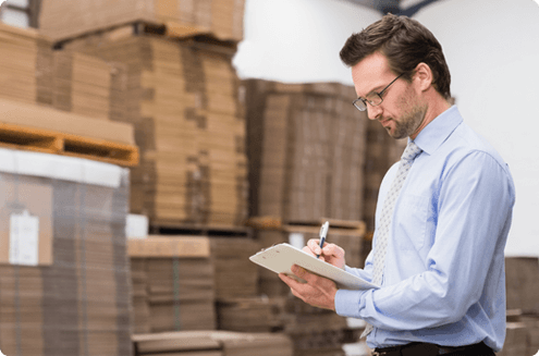 man with a clipboard taking notes in warehouse